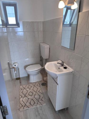 a white bathroom with a toilet and a sink at Casa Maria João in Lagos