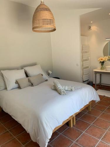 une chambre avec un grand lit blanc avec une lampe dans l'établissement Mas de la Pivoine, à Le Puy-Sainte-Réparade