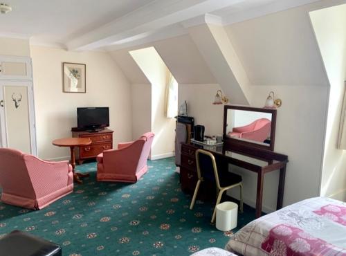 洛哈尔什教区凯尔高地The Lochalsh Hotel - Views of Skye Bridge的一间卧室，配有一张床和一张带镜子的书桌