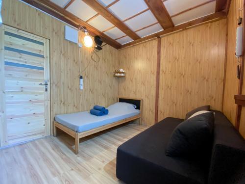 a small room with a bed and a door at Domek Letniczówka in Olsztynek