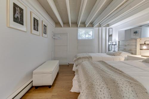 a white bedroom with three beds and a window at Le petit Manoir Spa et Vue sur rivière St Maurice in Grandes-Piles