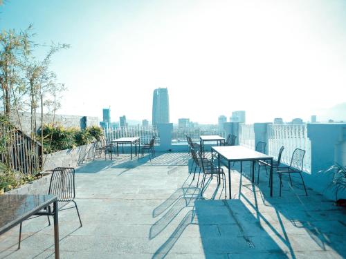 ダナンにあるIBIZA Danang Riverfront Hotelの屋根の上の一列のテーブルと椅子