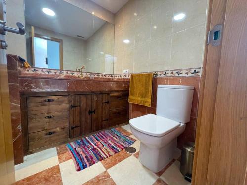a bathroom with a toilet and a mirror at Cozy apartment with large terrace next to the pool in La Tejita