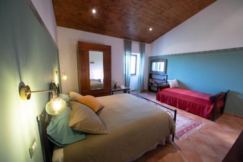 een slaapkamer met een groot bed en een rode bank bij Locanda Adriana in Montefranco