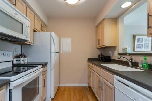 a kitchen with white appliances and wooden cabinets at Captain's Quarters Riverfront #1 in Nashville