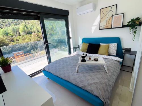 Un dormitorio con una cama azul y una mesa en Golden residence with heated pool, en Vinišće