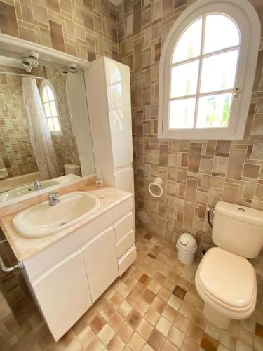 a bathroom with a sink and a toilet and a window at Villa Daurus in Vallauris