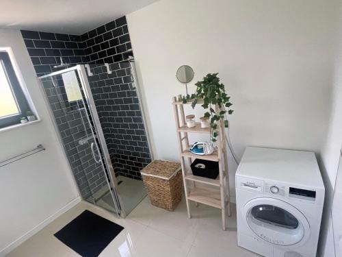 a bathroom with a washing machine and a shower at Golden residence with heated pool in Vinišće