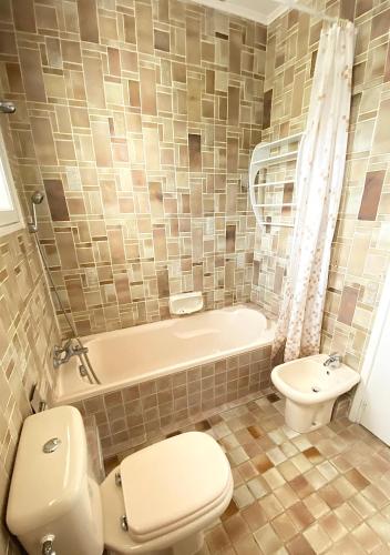 a bathroom with a toilet and a tub and a sink at Villa Daurus in Vallauris