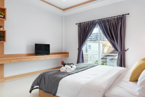 ein Schlafzimmer mit einem weißen Bett und einem Fenster in der Unterkunft Relax Pool Villa Near Walking Street,jacuzzi ,BBQ 5Bed 6Bath City house54 in Pattaya South
