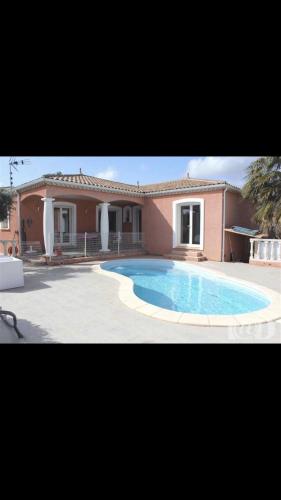 une grande piscine devant une maison dans l'établissement Villa Leprevost, à Béziers