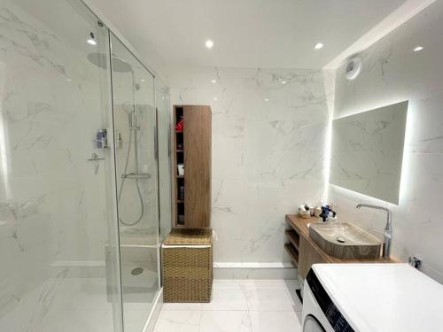 ein Bad mit einer Glasdusche und einem Waschbecken in der Unterkunft Superbe appartement Levallois-Perret 2 chambres - Luxurious 2BR flat in Levallois- 15 min from Opera in Levallois-Perret
