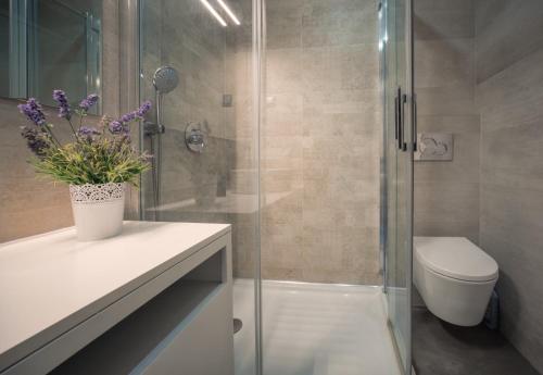 een badkamer met een toilet en een glazen douche bij Apartamento Deluxe AM in Quarteira