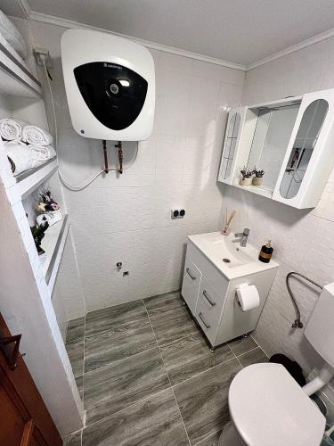 a white bathroom with a toilet and a sink at Cabana MADLUK in Arieşu de Pădure