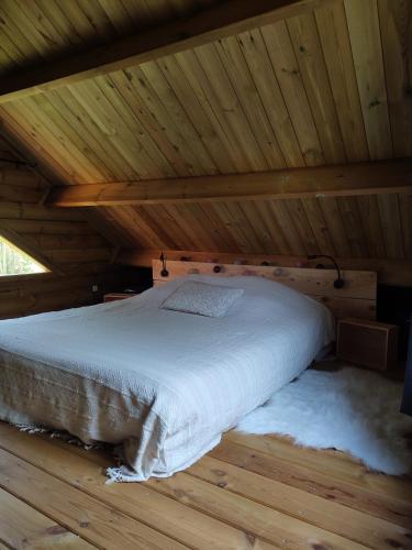 ein Schlafzimmer mit einem Bett in einer Holzhütte in der Unterkunft L'ETAPE PARIS-FONTAINEBLEAU in Pringy