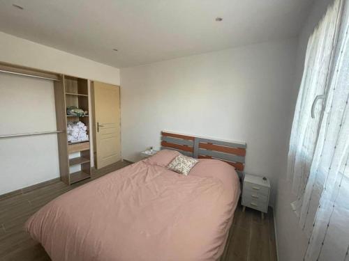 - une chambre avec un lit rose et une fenêtre dans l'établissement Appartement 53 m² - PIGNANS au coeur du var, à Pignans