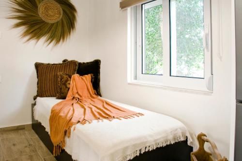 a bedroom with a bed with an orange dress on it at Sia's Sea House in Almyrida