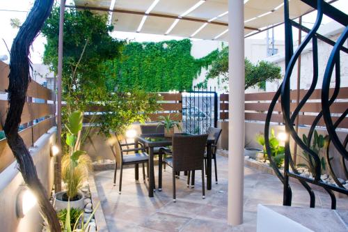 a patio with a table and chairs and plants at Sia's Sea House in Almirida