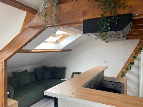 a living room with a green couch in a loft at Cocon in Courcy