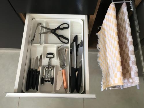 a drawer filled with cooking utensils in a kitchen at Cantinho Estrelado - Casa automatizada com ALEXA in Brotas
