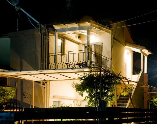 a white house with a balcony at night at Sia's Sea House in Almirida