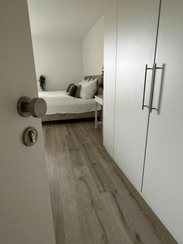 Habitación con cama y puerta que conduce a un dormitorio. en Wanderlust Petrisberg - Studio 54, en Trier