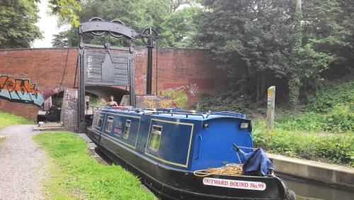 a blue boat is going through a tunnel at Narrowboat canal holiday from19th august in Aldermaston