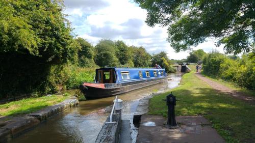 a blue boat traveling down a canal on a river at Narrowboat canal holiday from19th august in Aldermaston