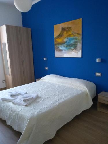 een blauwe slaapkamer met een bed met handdoeken erop bij Affittacamere Da Euro in La Spezia