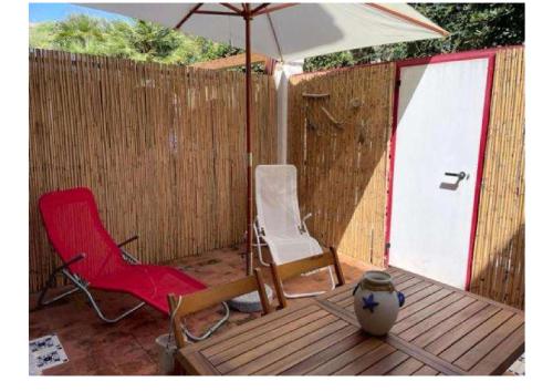 une terrasse avec deux chaises, un parasol et un vase dans l'établissement Casa Nadip, à Ustica