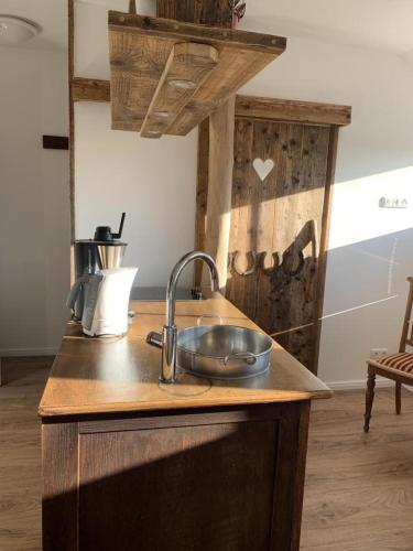 a kitchen with a sink and a wooden counter top at Hotel Fresena in Baltrum