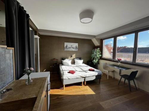 1 dormitorio con 1 cama y 1 mesa en una habitación en Bright/sunny/apartment w/shared rooftop terrace 360 view, en Budapest
