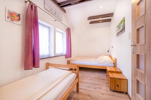 ポビエロボにあるDomki Tutti Fruttiのベッド2台と窓が備わる小さな客室です。