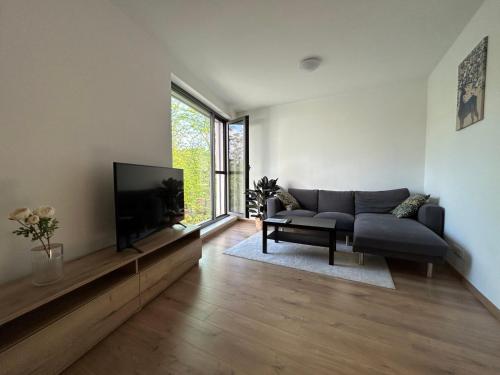 sala de estar con sofá y TV de pantalla plana en OTA-Group Luxury selection, en Bratislava