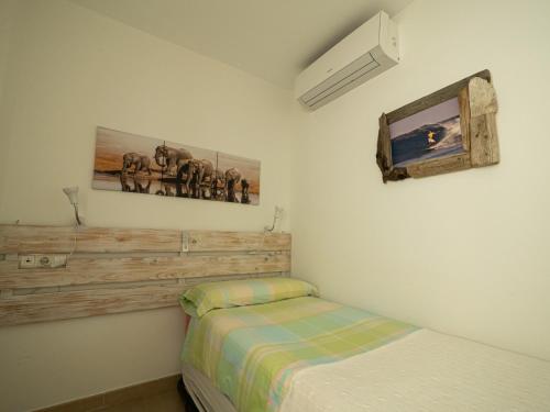1 dormitorio con 1 cama y TV en la pared en Lankarifa Apartment, en Tarifa