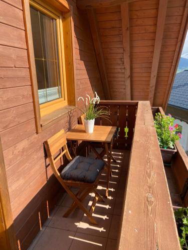 a table and chair on a porch with a window at Haus Sonnleitner Studio Rittisberg in Ramsau am Dachstein