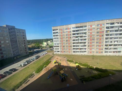 dwie osoby pracujące na deskorolce przed budynkiem w obiekcie DAK apartament w mieście Windawa