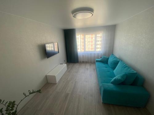 salon z niebieską kanapą i oknem w obiekcie DAK apartament w mieście Windawa