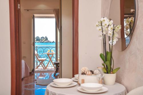 a table with plates and a vase with flowers on it at Beach House in Petrovac na Moru