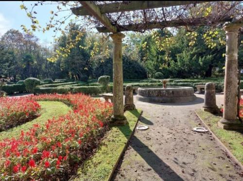 a garden with flowers and a pergola at Apartamento Palacio Valdés, centro Avilés, con parking in Avilés