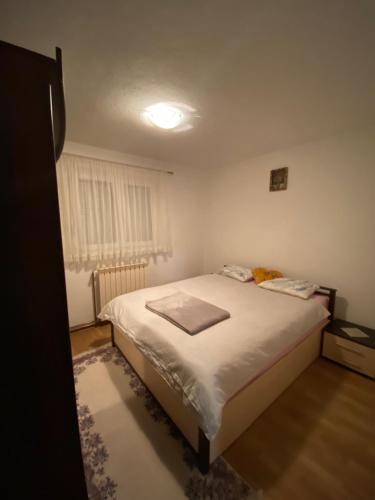 um pequeno quarto com uma cama e uma janela em Villa Emina em Sarajevo