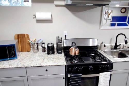 a kitchen with a stove with a tea kettle on it at Spacious Suite Close to Downtown Indy/ King Bed in Indianapolis