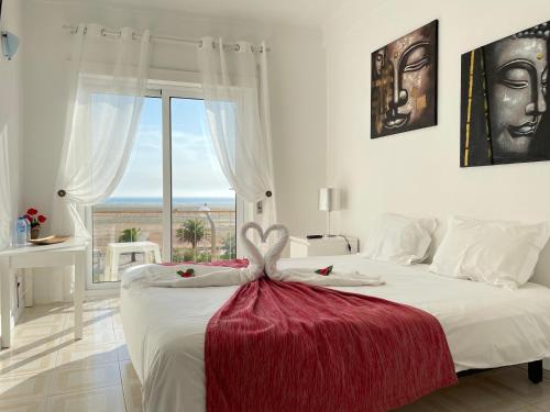 a bedroom with a large white bed with a large window at Stella di Mare Alojamento Local in Figueira da Foz