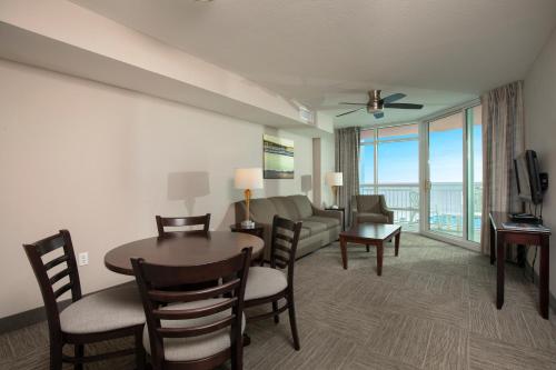 un soggiorno con tavolo, sedie e divano di Prince Resort a Myrtle Beach