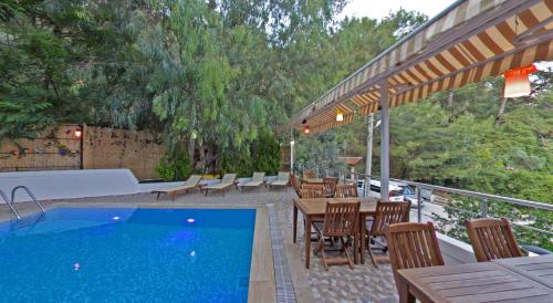 a patio with a swimming pool and tables and chairs at Eden Pyara Hotel Turunc in Turunc