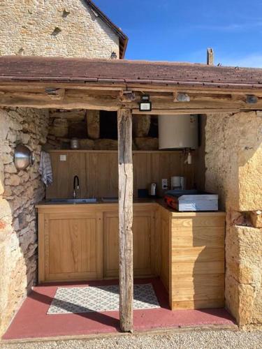 une cuisine dans un bâtiment en pierre avec un comptoir dans l'établissement Cabane du Canada, à Azerat