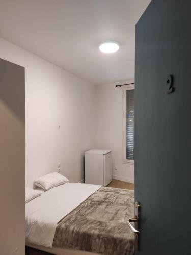 a bedroom with a bed and a window at Le Palmier in Saint-Denis