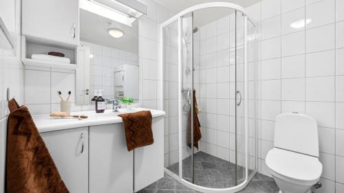 a white bathroom with a shower and a toilet at Very central location in Bergen in Bergen