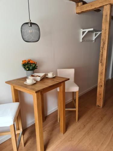 a wooden table and chairs with a vase of flowers on it at Lgh centralt i Ystad in Ystad