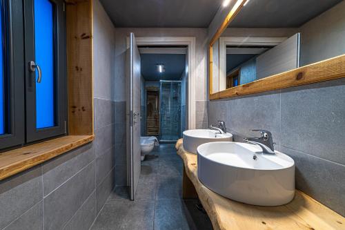 uma casa de banho com 2 lavatórios e 2 WC em Chalet Margoni em Canazei